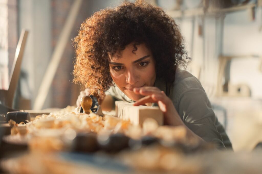 Handwerker Website: Handwerkerin schleift Holz